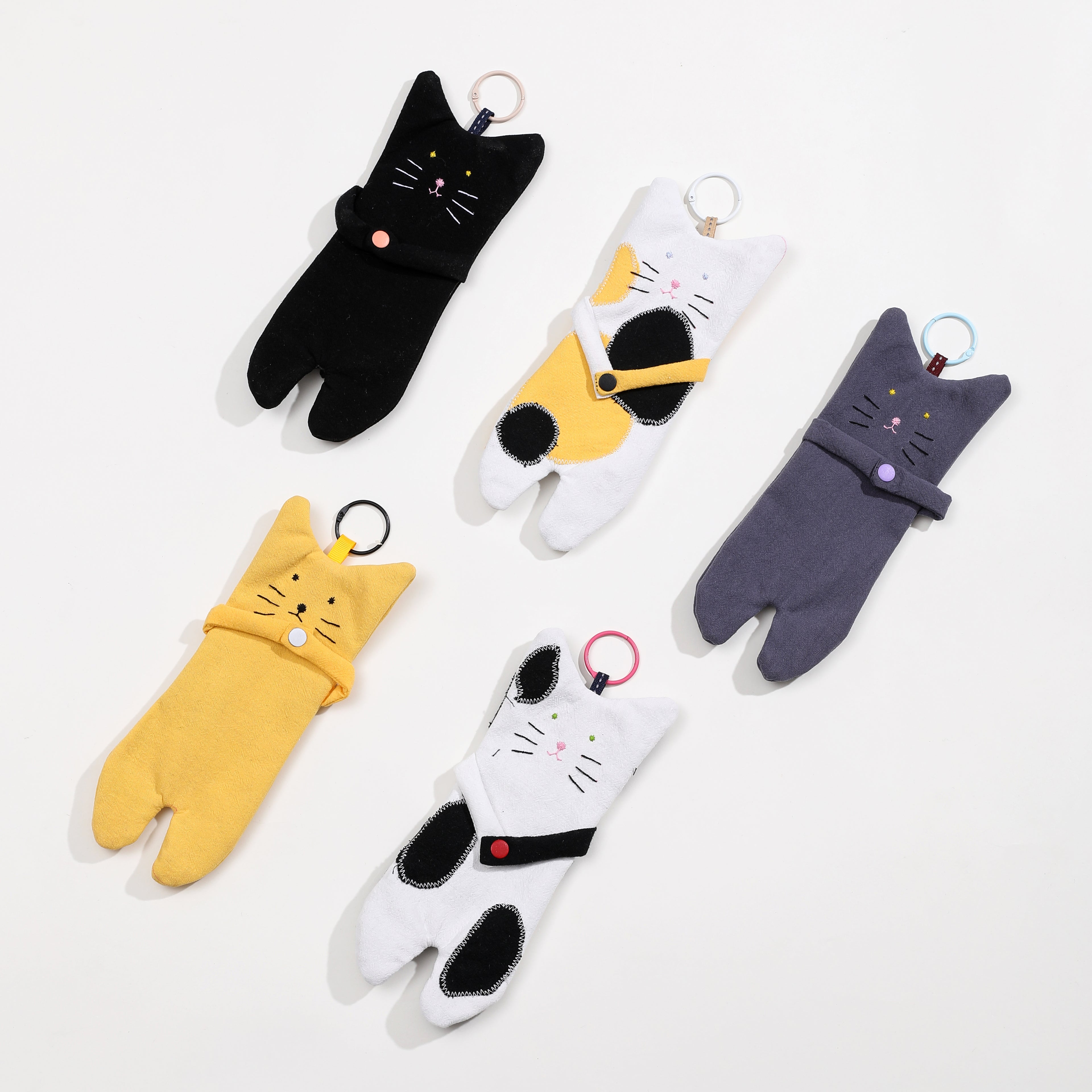 Five cat-shaped bag in black, white, yellow, and gray on a white background